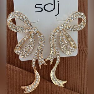 Brand new bow design post earrings . Gold and bling .